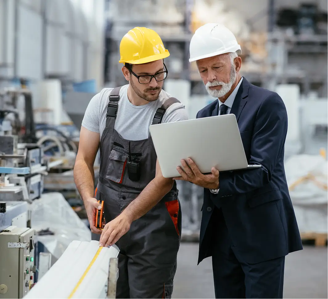 Two construction professionals reviewing plans at a site.
